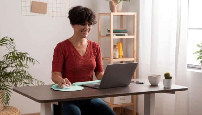 Enables-Remote-Working - Startup Editor | Startup Editor Cloud Migration As A Business Enabler shown through a remote professional working on a laptop in a modern workspace, symbolizing cloud-powered productivity, flexible work environments, and seamless access to business applications from anywhere.