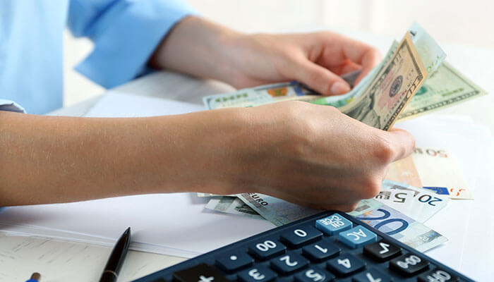 Cash Accounting - Startupeditor | Startup Editor Cash vs accrual accounting concept showing person counting money with calculator and financial documents