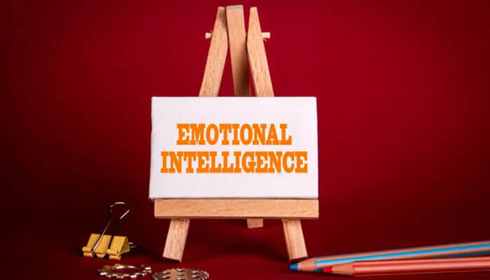  small easel displaying the words EMOTIONAL INTELLIGENCE, symbolizing the importance of emotional intelligence as a key component of developing effective leadership skills.