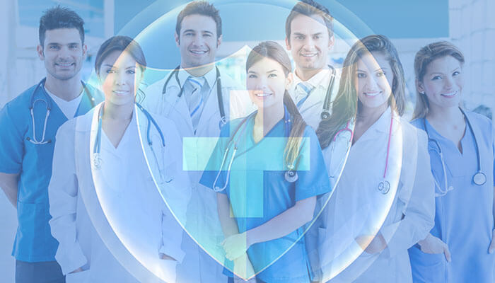 How Healthcare Organizations Can Protect Their Employees | Startup Editor Group of healthcare employees, including doctors and nurses, standing together in a hospital, symbolizing teamwork and collaboration in the medical field.