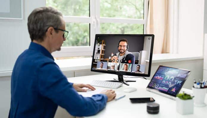 Professional conducting a virtual meeting on a webinar platform, engaging with remote participants on a screen, highlighting the seamless integration of remote communication tools for business success