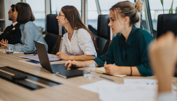 Team of professionals working together in a meeting room, discussing strategies for smarter operations in business management.