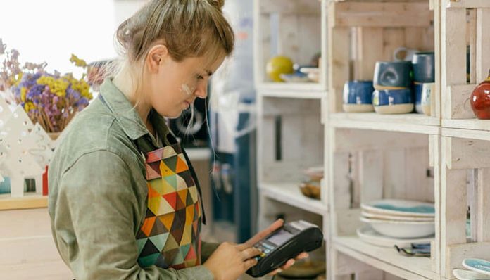 Retail worker using a tablet to check stock levels, showing the importance of improving on-shelf availability in e-commerce and omnichannel retail