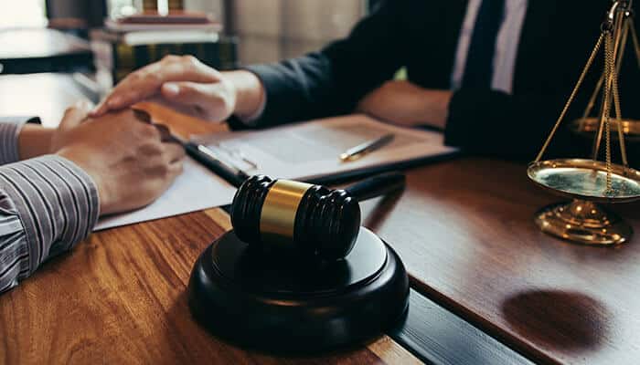 Legal consultation with a lawyer, with a gavel on the table, discussing a case involving someone who is partially at-fault for an accident.