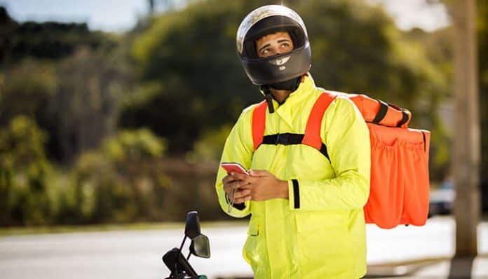 Food delivery rider using smartphone with address lookup for delivery accuracy to ensure correct and timely customer deliveries