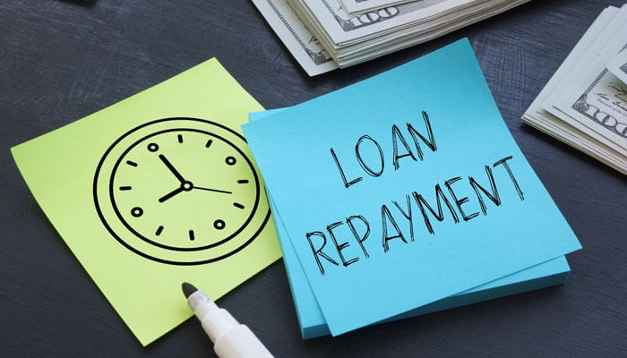 Payroll Loan Repayments - Startupeditor | Startup Editor Sticky notes showing a clock and the phrase Loan Repayment beside cash bundles, representing financial decisions in payroll loan vs personal loan.