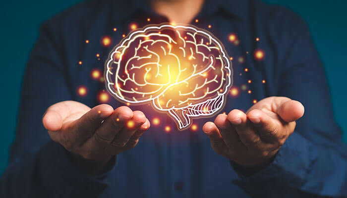 Repetition And Recall As The Engine Of Memory - Startupeditor | Startup Editor Person holding a glowing brain illustration, symbolizing the impact of neuroscience in digital learning on focus, memory, and engagement