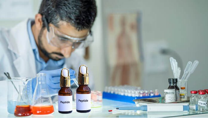 Scientist working in a laboratory with research peptides bottles and scientific equipment, focusing on peptide synthesis and molecular research.