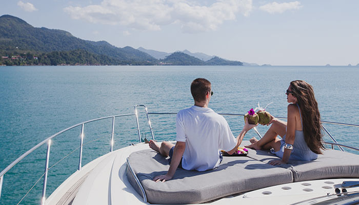 Couple relaxing on a luxury yacht deck, enjoying drinks and ocean views during Luxurious Yacht Events