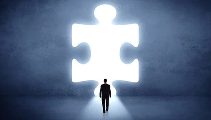 A silhouette of a person standing in front of a large puzzle piece illuminated by light, symbolizing the potential and challenges in unlocking the full power of Generative AI.