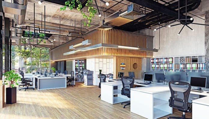 Modern energy-efficient office space with natural light, open workstations, ergonomic chairs, and sustainable design elements for a green workplace.
