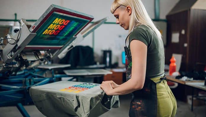 Professional Printing Services worker screen printing colorful brand design on fabric to help businesses build strong brands