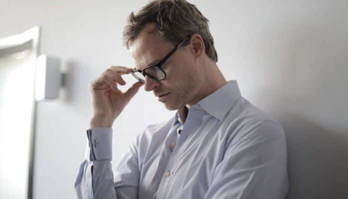 Stressed professional after being laid off from work, representing career challenges and the importance of finding tips for recovery