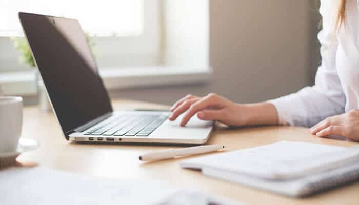 A professional using a laptop at a desk, symbolizing how Enterprise AppGen empowers startups to create and manage applications quickly and efficiently.
