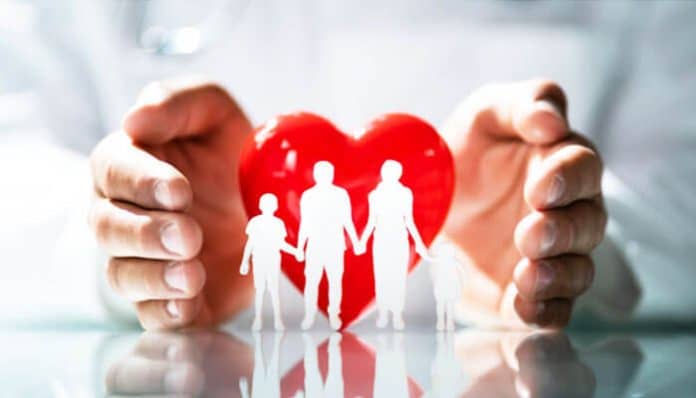 Hands protecting a family with a red heart symbol, representing protection and security while busting common health insurance myths for families