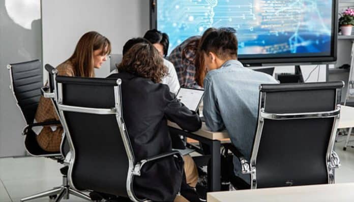 Team collaborating on business roadmaps during a strategy meeting with digital planning tools displayed on a screen.