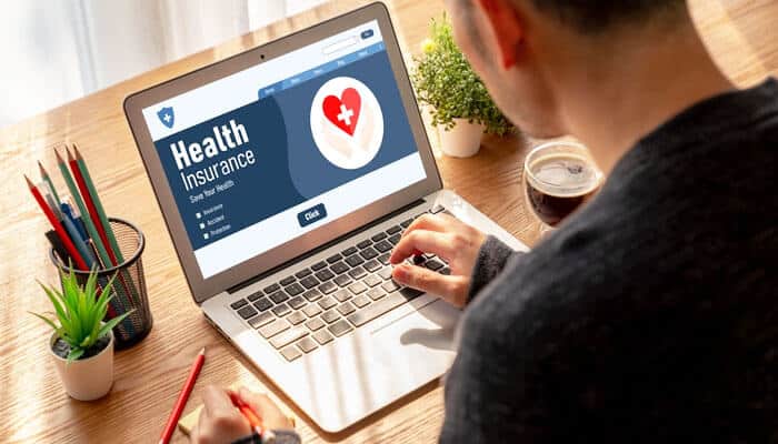 Man researching health insurance myths on a laptop, exploring facts and misconceptions about coverage, costs, and family protection plans.