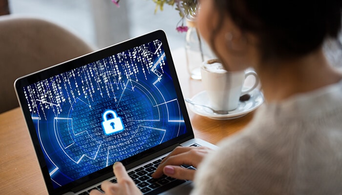 Professional using laptop with digital lock screen symbolizing advanced Cybersecurity protection and data encryption.