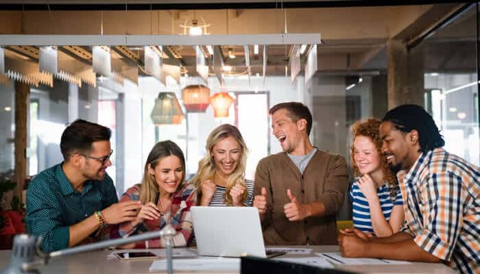 Startup team celebrating employee milestones together in a modern office, showing teamwork, recognition, and a positive company culture.