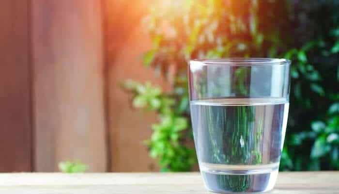 Eco-friendly Branded Glassware placed on a wooden table, symbolizing sustainability and purity in modern corporate events.