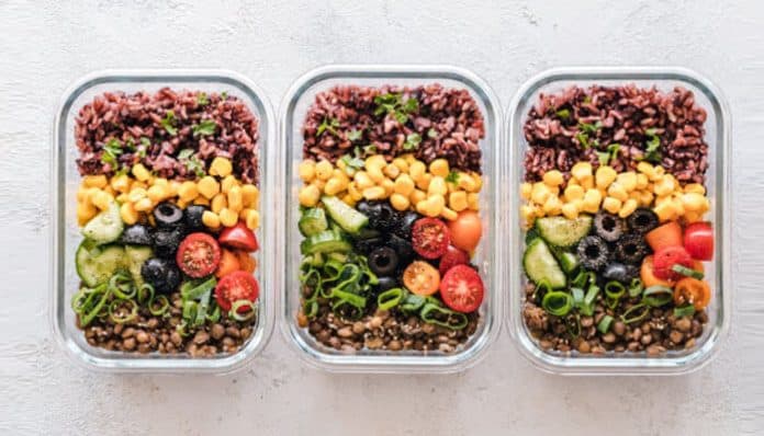Colorful meal prep bowls with fresh vegetables, grains, and legumes arranged neatly, showcasing balanced nutrition and the joy of Wholesome Eating