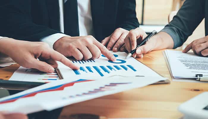 Financial Advisers reviewing charts and graphs with clients to provide investment strategies and financial planning guidance.