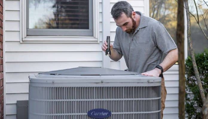 A technician performing maintenance on an HVAC system, showcasing the importance of certifications for home service firms to build trust and ensure expertise.
