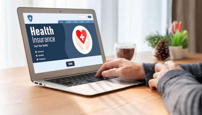 A student browsing a health insurance website on a laptop, illustrating the importance of health insurance abroad for students when studying overseas.