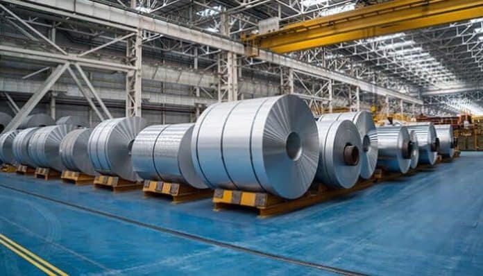Large aluminum rolls stored inside an industrial facility, representing aluminum sheet metal fabrication for manufacturing projects.
