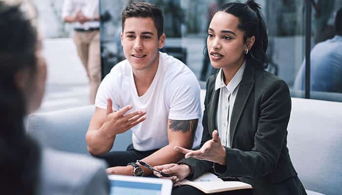 Two startup founders discussing global market strategies with a consultant, demonstrating global thinking for startup founders aiming for international expansion.