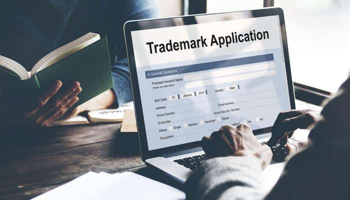 Laptop screen displaying a Trademark Application form, showing the online process to register a trademark in India for legal brand protection.