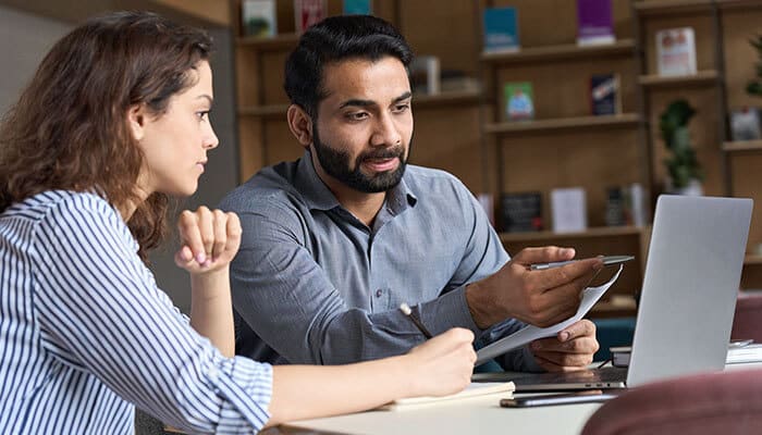 Two entrepreneurs collaborating and sharing ideas, demonstrating how to educate yourself as an entrepreneur to enhance business skills and strategies.