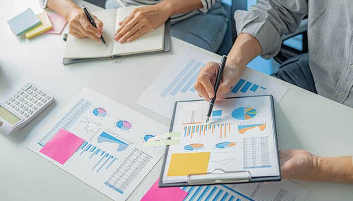 Business professionals reviewing custom business signage data and design plans, emphasizing the importance of effective branding strategies for startups.