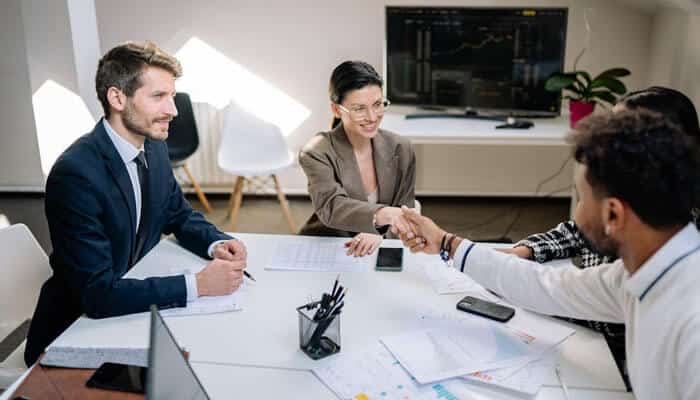 Business professionals shaking hands in a meeting room, symbolizing strategic partnerships and collaboration for startup funding and business loan strategy success