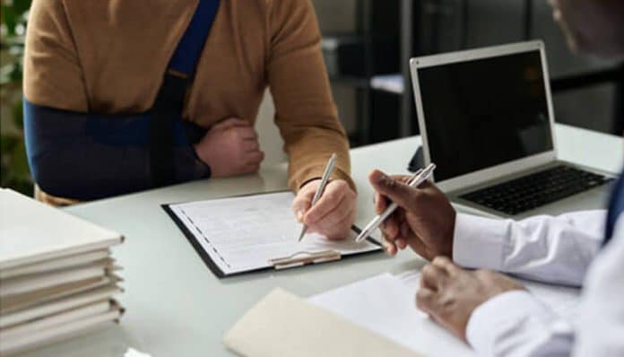 Injured person meeting an attorney to discuss personal injury settlement claim paperwork