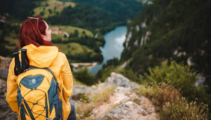 Hiker overlooking scenic mountains and river landscape in New Zealand for adventure seekers exploring nature trails