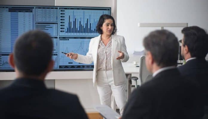 A businesswoman presenting global market data to a team during a strategy meeting, illustrating global thinking for startup founders aiming for international growth