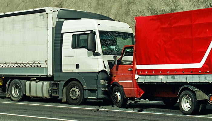 Commercial truck accident involving two vehicles on the highway, highlighting the importance of MCS-90 insurance for victim compensation