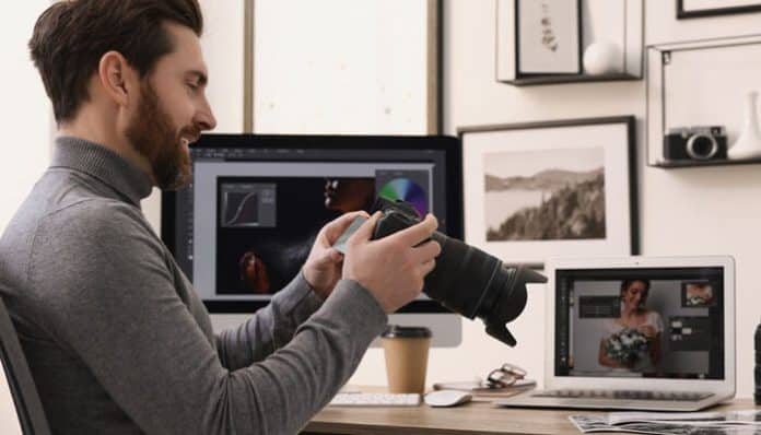 Photographer reviewing camera settings and editing workflow at a desk as part of learning how to start a photography business