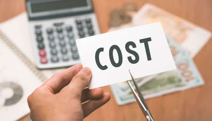 A person cutting a card with the word cost illustrating business recovery and insolvency