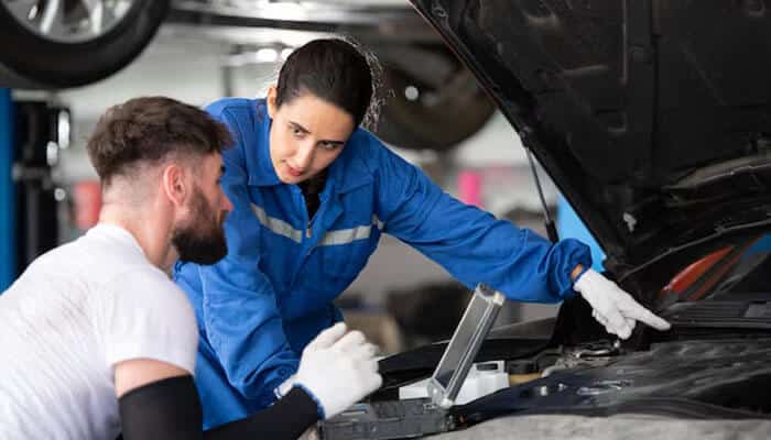 Mechanics discussing affordable solutions to help customers afford car repairs, ensuring they understand their options for cost-effective vehicle maintenance