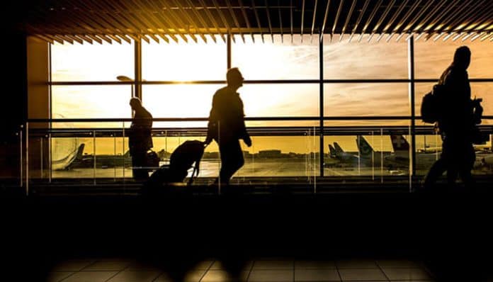 Managing risks while traveling for business, entrepreneurs navigating through the airport during a busy business trip
