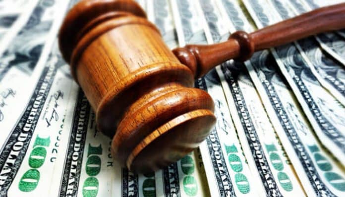 A judge’s gavel resting on a spread of hundred dollar bills, symbolizing legal compensation and the factors that influence a strong settlement offer.