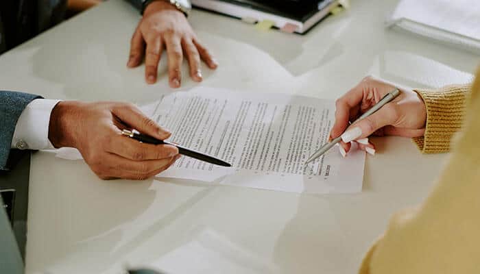 How to sell a business note shown through a promissory note agreement being reviewed and signed