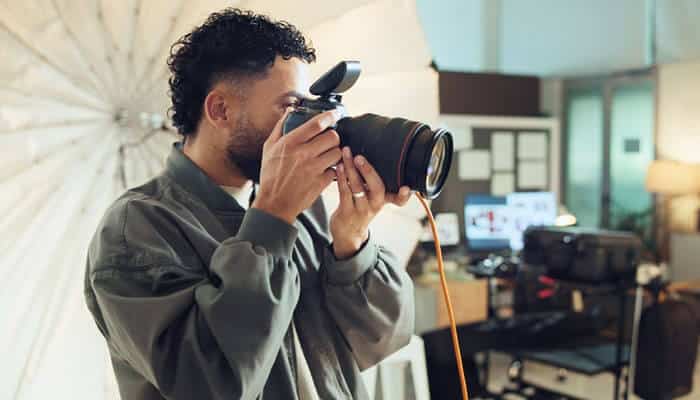 Professional photographer taking studio shots with DSLR camera, representing how to start a photography business successfully