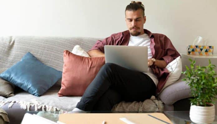 A founder working on a laptop from home, managing side income and time effectively to fund your startup dream while balancing work and personal life.