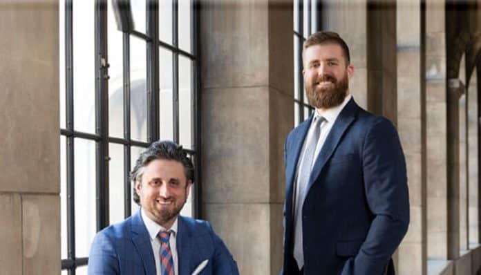 Attorneys from Liberty Law Group posing confidently in professional business attire inside a law office
