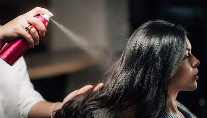 Professional stylist using sea salt spray to create soft, textured waves