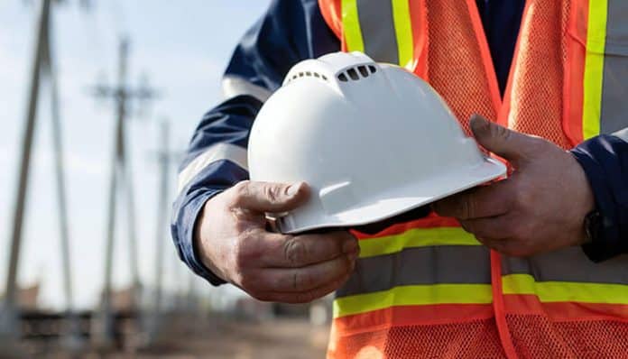 Construction worker holding a safety hard hat, highlighting the importance of upgrading to type 2 helmets for enhanced protection