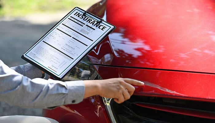 Bailey & Burke Attorneys reviewing an insurance document at the scene of a car accident, assisting clients in navigating the claims process for fair compensation